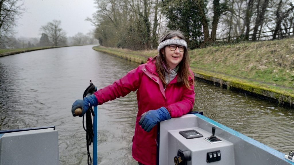 Clare at the helm of Bartimaeus, dressed for cold weather.
