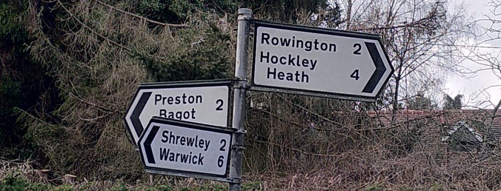 Road sign pointing in three directions:
Rowington 2
Hockley Heath 4
Preston Bagot 2
Shrewley 2
Warwick 6