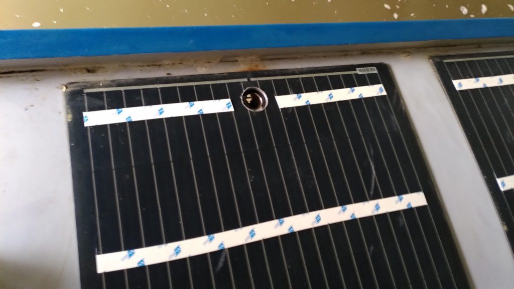 View of solar panel on narrowboat roof with hole drilled through at one side.