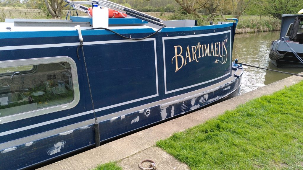 Back end of narrowboat Bartimaeus with large amounts of grey paint below the gunwale.