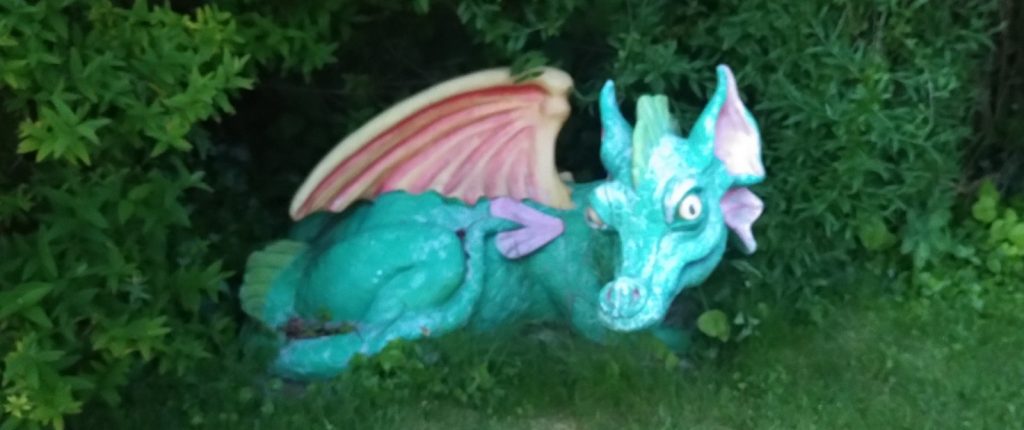 A plastic dragon statue.  The dragon is reclining with a wing lifted.