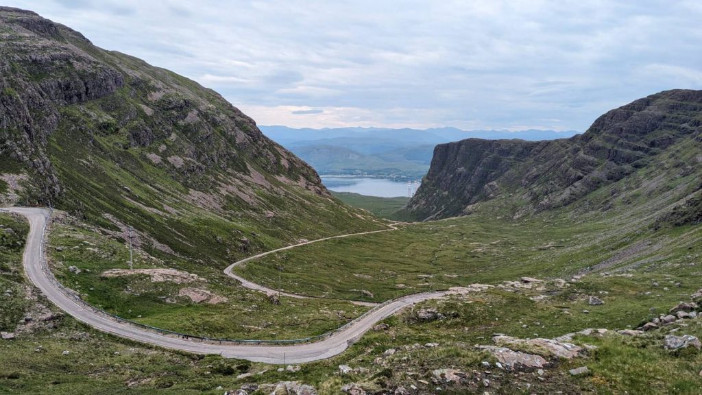 Looking back from the viewpoint just above the hairpin bends.  The road can be seen snaking down the glen towards the sea, just visible four miles and 2000 feet below.