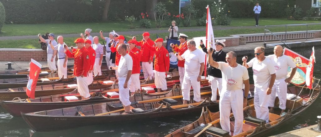 A lock full of swan uppers standing in their boats raising a toast to The King.