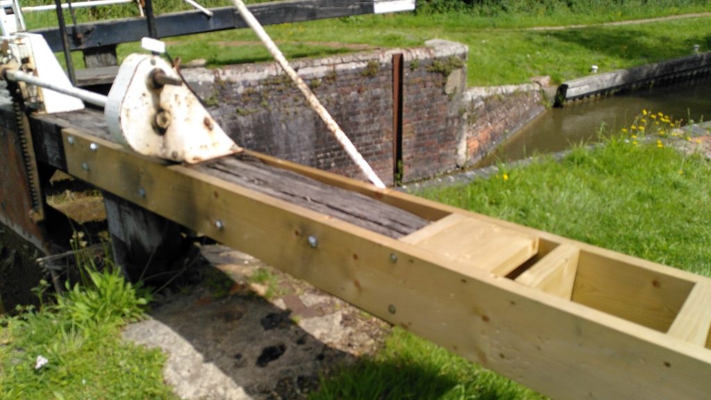 The arm of a lock gate has broken off quite near the pivot.  Planks have been bolted to the remaining arm and a box structure created to add strength and rigidity.
