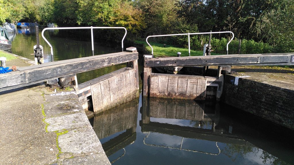 Head gates at a double lock.  The gates are nearly closed, but do not line up.  The left hand gate appears higher in the middle because it is not seated correctly in its bearing.