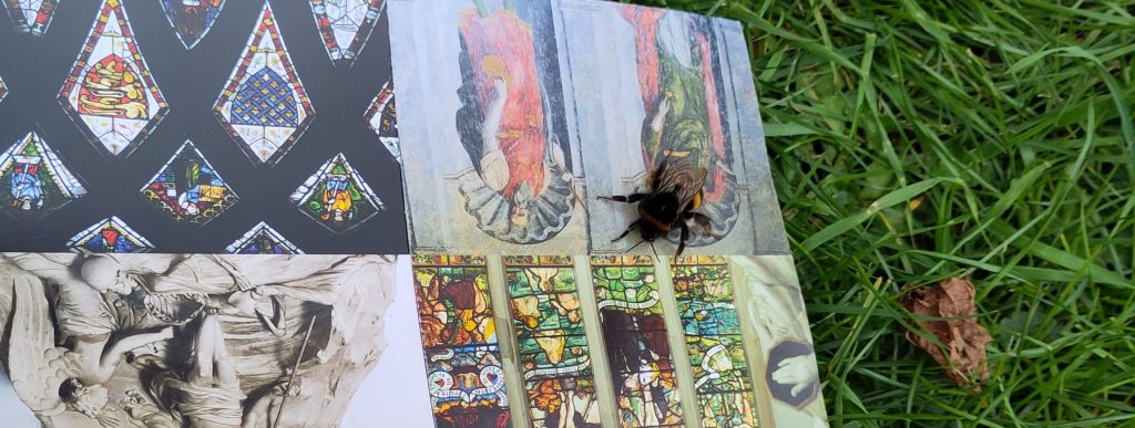 Bumblebee on leaflet.  A leaflet with pictures of various features inside a church is unfolded with a large bumblebee resting on it.