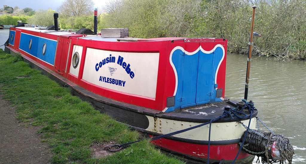 Cousin Hebe.  A traditional style narrowboat moored against a grassy towpath.