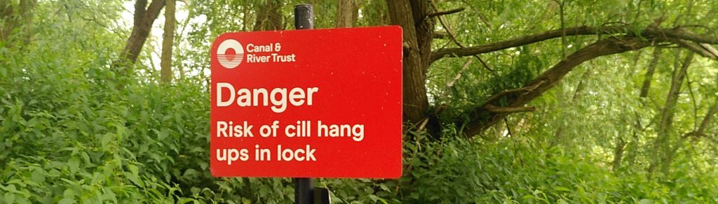 Danger sign. A red sign says "Danger Risk of of cill hang ups in lock".