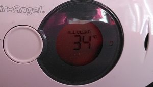 Temperature. A carbon monoxide monitor in the bedroom also displays the temperature. The display is showing "ALL CLEAR 34°C".